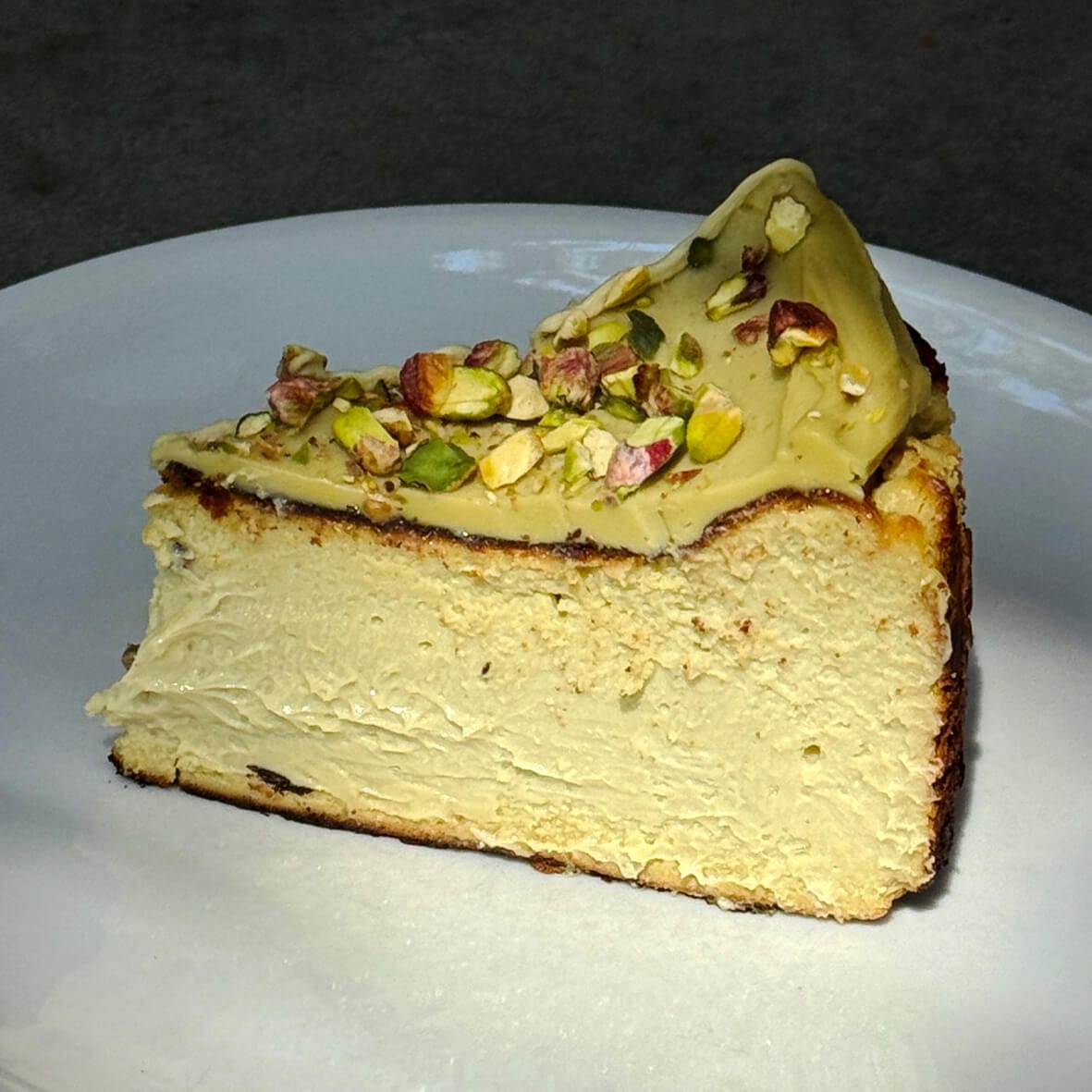 Шматочок на тарілці фісташковий баскський чизкейк Cheesecake Family - найбільша колекція чизкейків в Україні