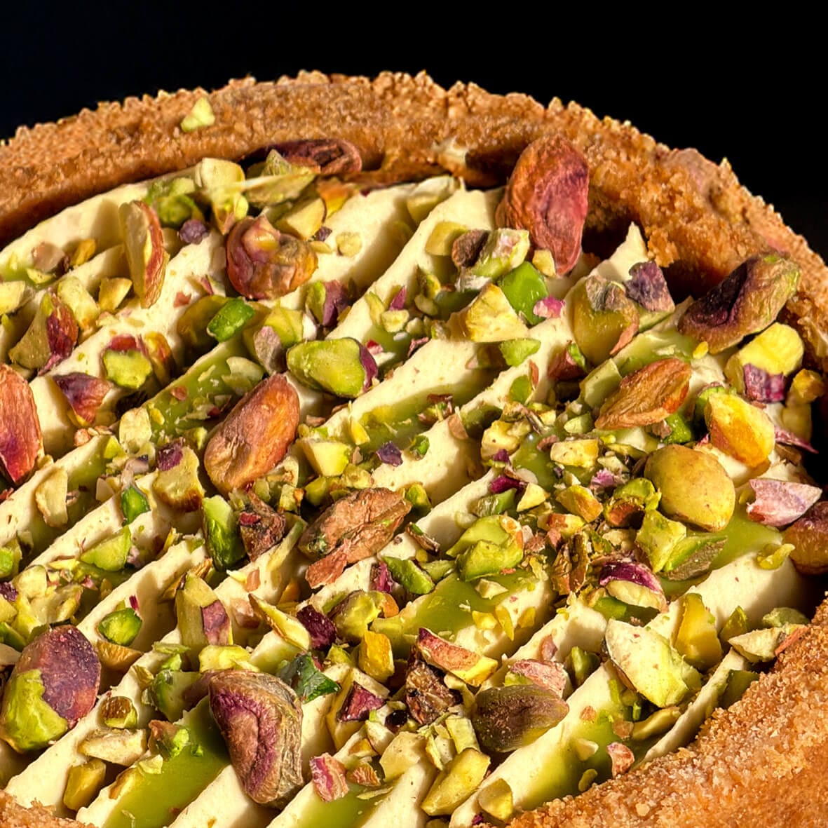 Фісташковий бенто чизкейк Cheesecake Family детальна текстура декору: крем та подрібнена фісташка крупним планом