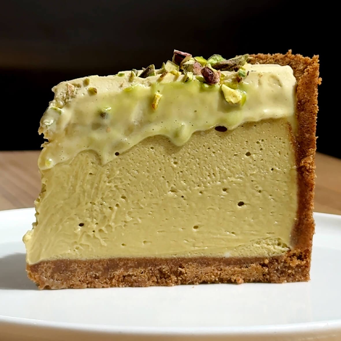 Cheesecake Family Чизкейк Фісташковий — Шматочок фісташкового чизкейку крупно вид збоку Pistachio Cheesecake